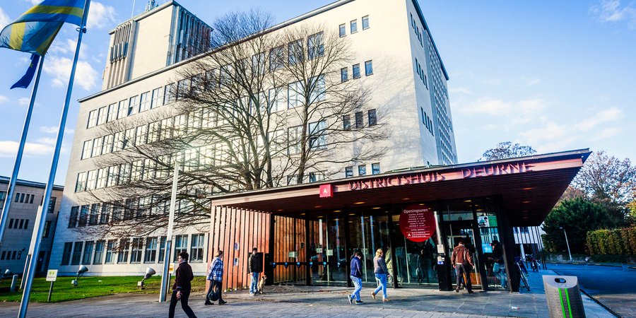 Verschillende mensen staan voor het districtshuis van Deurne Verschillende mensen staan voor het districtshuis van Deurne